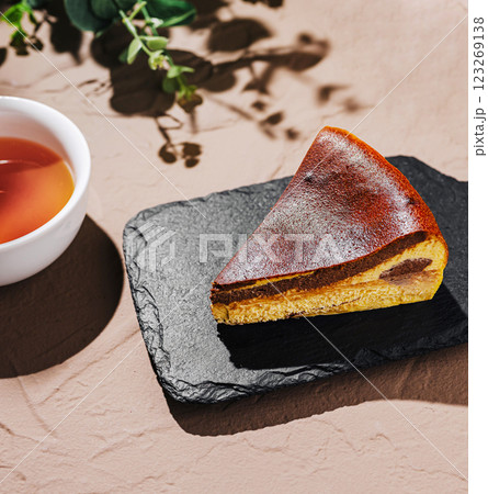 Richly flavored cheesecake served with a cup of warm tea Richly flavored cheesecake served with a cup of warm tea 123269138