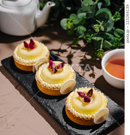 Sweet lemon tarts garnished with rose petals on a serving plate Sweet lemon tarts garnished with rose petals on a serving plate 123269139