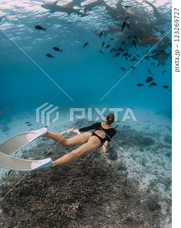 Slim sexy woman glides in tropical sea with nurse sharks in Maldives 123269727