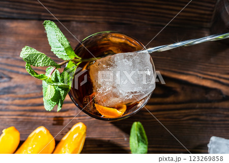 Macro photo of a piece of ice in a glass. Cocktail view from above. Bartender's spoon and ice in a cocktail. 123269858