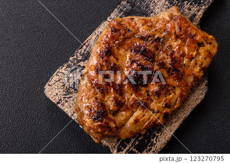 Juicy pork steak baked on the grill with salt, spices and herbs 123270795