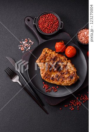Juicy pork steak baked on the grill with salt, spices and herbs 123270804