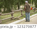 Worker mows grass with a petrol trimmer in a city park. The process of mowing a lawn with a manual lawn mower. Gardening tools and equipment 123270877
