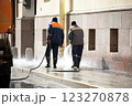 The municipal service washes the streets. An employee washes the street from dirt with high pressure. Street cleaning. Spring. 123270878