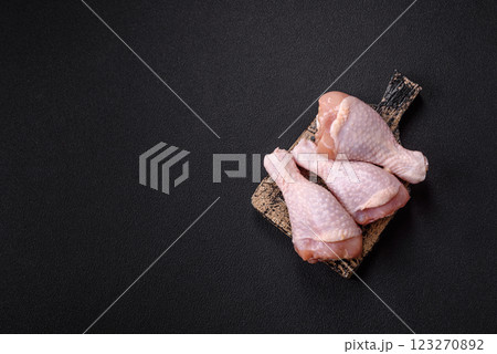 Raw chicken legs with salt, spices and herbs 123270892