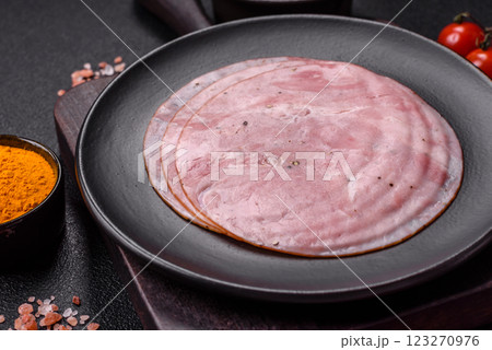 Smoked ham with salt, spices and herbs cut into round slices 123270976