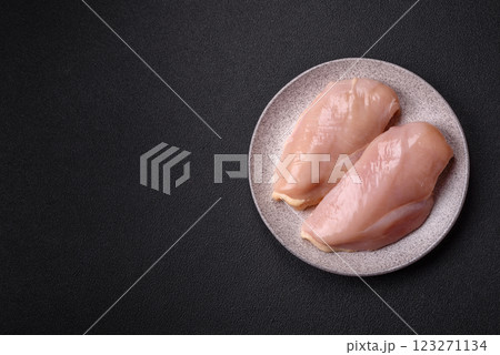 Pieces of raw chicken or turkey fillet with salt, spices and herbs 123271134
