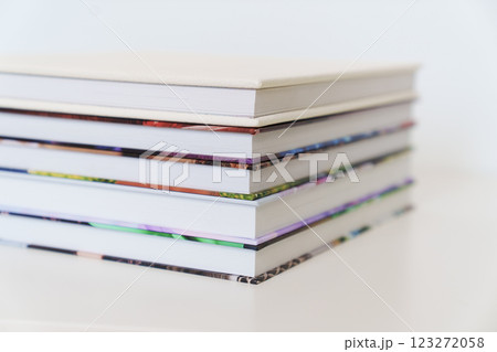 Folded photo books with white leather and multi-colored photo covers. 123272058