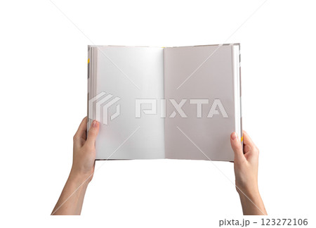A person holding an open, blank book or notebook, showcasing clean, white pages for writing, reading 123272106