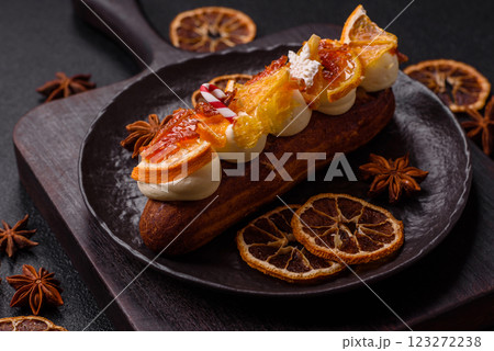Delicious sweet eclair with chocolate filling, covered with cream 123272238