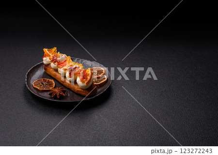 Delicious sweet eclair with chocolate filling, covered with cream 123272243