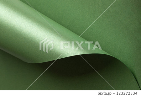 Emerald green paper background with a pearlescent, glossy texture and shimmering wavy edges. Deep Emerald green paper background with a pearlescent, glossy texture and shimmering wavy edges. Deep 123272534