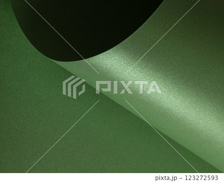 Forest green paper background with a pearlescent, glossy texture and shimmering wavy edges. Rich 123272593