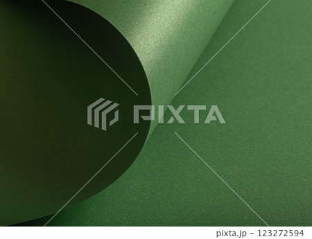Forest green paper background with a pearlescent, glossy texture and shimmering wavy edges. Rich 123272594
