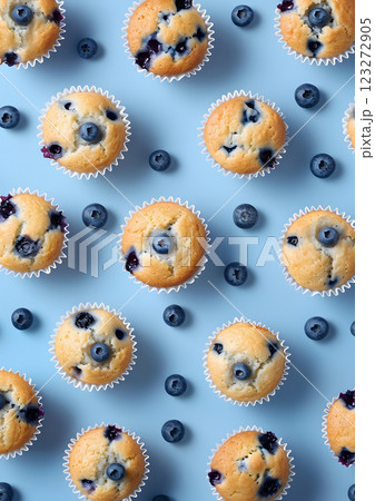 Enjoy the beautiful top view of homemade blueberry muffins with fresh blueberries on a soft pastel blue background. Ideal for those who love baking and indulging in delicious desserts 123272905