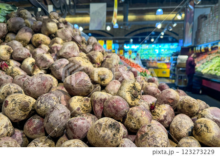 A large pile of freshly harvested beets with dirt still on them is displayed prominently in the produce section of a grocery store A large pile of freshly harvested beets with dirt still on them is displayed prominently in the produce section of a grocery store 123273229