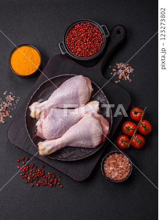 Raw chicken or turkey legs with salt, spices and herbs 123273802
