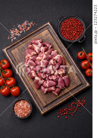 Raw chicken hearts with salt, spices and herbs 123274223
