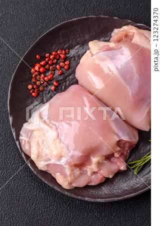 Fresh raw chicken thigh fillets with salt, spices and herbs Fresh raw chicken thigh fillets with salt, spices and herbs 123274370