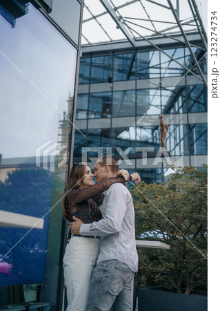 Romantic scene of a couple of lovers sitting at a table outside a cafe. The man and woman are kissing gently, holding hands, which emphasizes their closeness and intimacy. 123274734