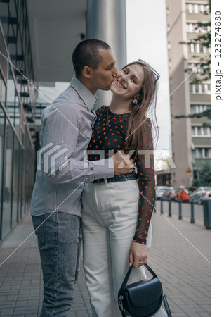 Romantic couple embracing and sharing a kiss in an urban setting. Young stylish man and woman in trendy outfits enjoying a moment of love on a city sidewalk. Modern architecture in the background. Romantic couple embracing and sharing a kiss in an urban setting. Young stylish man and woman in trendy outfits enjoying a moment of love on a city sidewalk. Modern architecture in the background. 123274880
