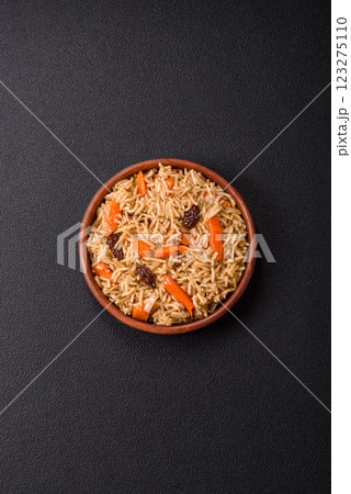 Delicious fresh pilaf with rice, carrots, meat, onions, spices and berries Delicious fresh pilaf with rice, carrots, meat, onions, spices and berries 123275110