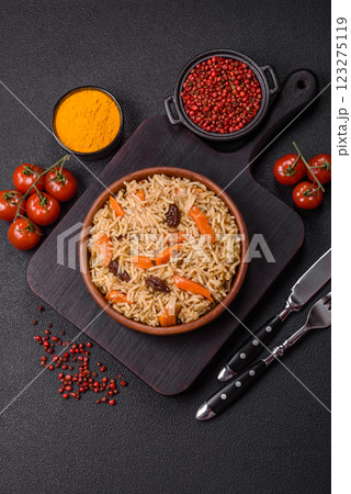 Delicious fresh pilaf with rice, carrots, meat, onions, spices and berries 123275119