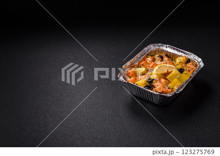 Baked salmon pieces with potatoes, cheese and olives 123275769