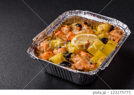 Baked salmon pieces with potatoes, cheese and olives 123275773
