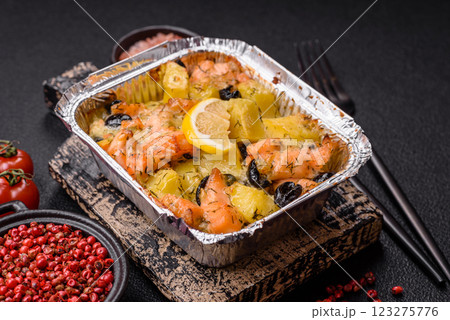 Baked salmon pieces with potatoes, cheese and olives Baked salmon pieces with potatoes, cheese and olives 123275776