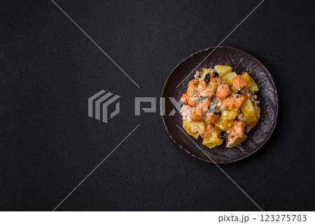 Baked salmon pieces with potatoes, cheese and olives Baked salmon pieces with potatoes, cheese and olives 123275783