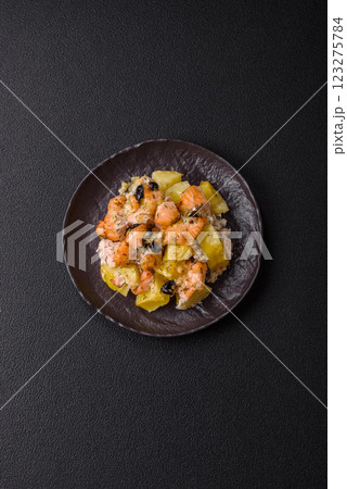 Baked salmon pieces with potatoes, cheese and olives Baked salmon pieces with potatoes, cheese and olives 123275784