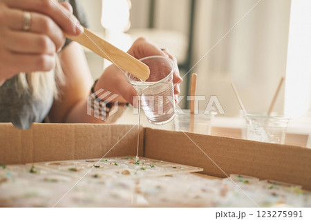 Hands creating resin art: female, caucasian, adult crafting with epoxy resin Hands creating resin art: female, caucasian, adult crafting with epoxy resin 123275991