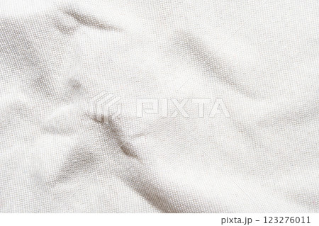 Close-up texture of white wrinkled canvas fabric with subtle shadows Close-up texture of white wrinkled canvas fabric with subtle shadows 123276011