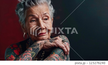 elderly woman with striking tattoos and a serene expression, embodying grace, individuality, and the beauty of self-expression through art and life experiences 123276240