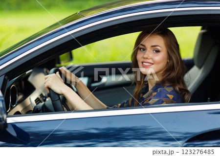 Happy woman driver at car smiling. Cute young happy brunette female driving car vehicle Happy woman driver at car smiling. Cute young happy brunette female driving car vehicle 123276485
