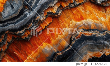 orange and black rock formations, displaying layered textures and vivid colors, evoking the raw beauty of nature geological wonders, illuminated in dramatic lighting 123276670