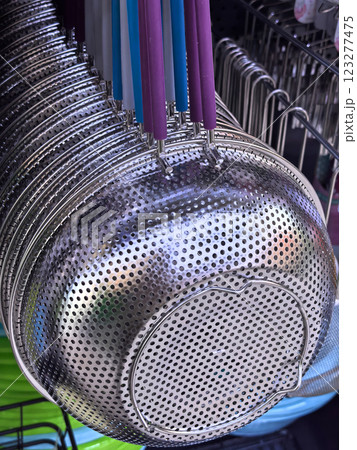 Hanging metal colanders in a vibrant market on a sunny afternoon 123277475