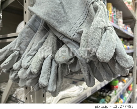 Soft gray gardening gloves hanging in a vibrant store aisle for home improvement Soft gray gardening gloves hanging in a vibrant store aisle for home improvement 123277483
