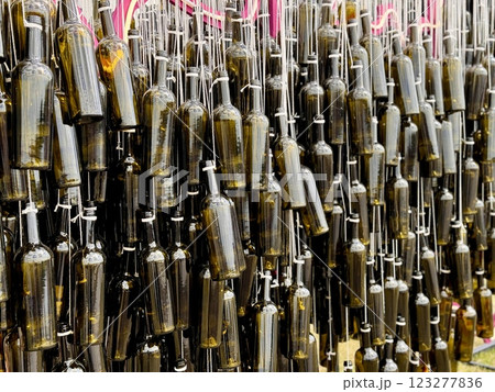 Empty dark wine bottles in close-up at an exhibition and sale of high-quality alcohol. A large number of bottles in the form of silhouettes and shapes in the design with garters and bows. Stylish Empty dark wine bottles in close-up at an exhibition and sale of high-quality alcohol. A large number of bottles in the form of silhouettes and shapes in the design with garters and bows. Stylish 123277836