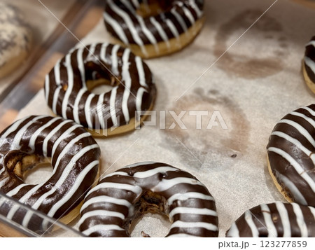 Delicious and irresistible chocolatecovered donuts, beautifully adorned with lovely white icing stripes on top. Close-up. 123277859