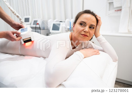 Woman undergoing a body treatment session in a wellness center 123278001