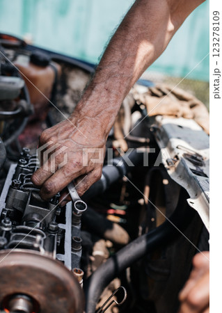 A worker repairs the cylinder head of an automobile engine. Oil removal valve. Car repairs. Car service A worker repairs the cylinder head of an automobile engine. Oil removal valve. Car repairs. Car service 123278109