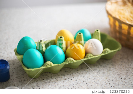 Ready-painted eggs stand on the table with paints and a wicker basket on a sunny day. Easter 123278236