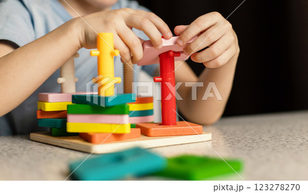 Close-up of children's hands playing with an educational multi-colored puzzle toy 123278270