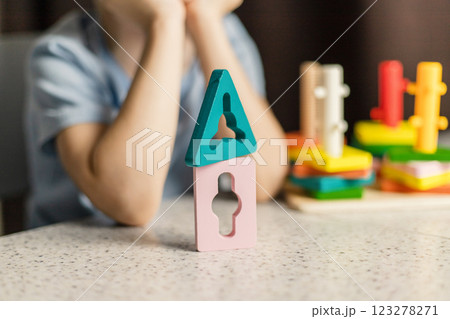 Close-up of wooden parts of a multi-colored educational toy against the background of children's hands Close-up of wooden parts of a multi-colored educational toy against the background of children's hands 123278271