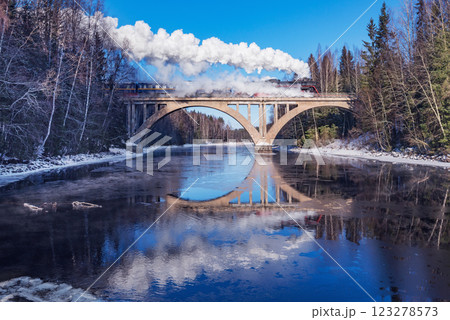 Retro steam train moves above the river. Retro steam train moves above the river. 123278573