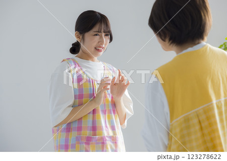 エプロンをつけて話す女性 エプロンをつけて話す女性 123278622