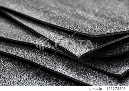 Roofing felt roll partially unrolled showing its inner layers, lying on a roof surface ready for installation 123278893