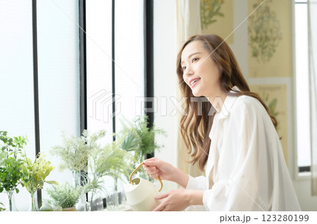 植物に水を与えながらガーデニングを楽しむ女性 123280199